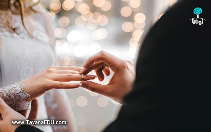 ازدواج و دامادی در حال گذاشتن حلقه در دست عروس
